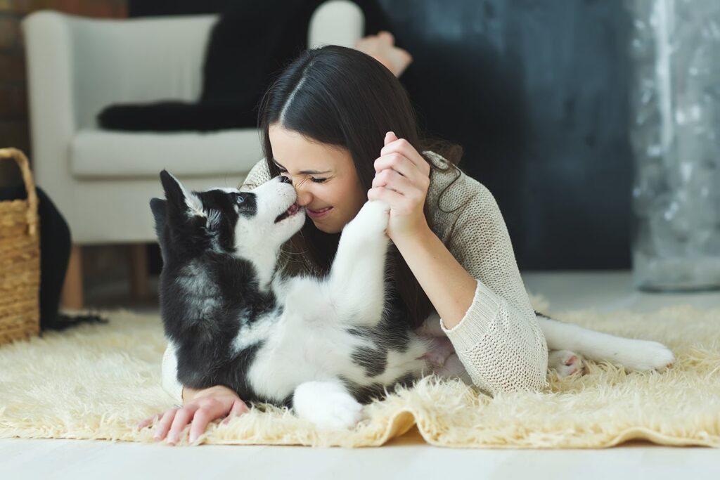 woman cuddling dog on fuzzy rug