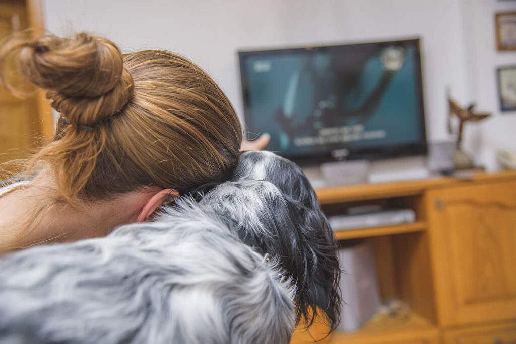 woman watching tv with dog